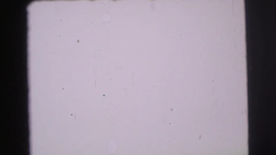 Pale overexposed 8mm frame from the 1971 Yellowstone clip, with gate edges, dust specks, and little readable subject detail.