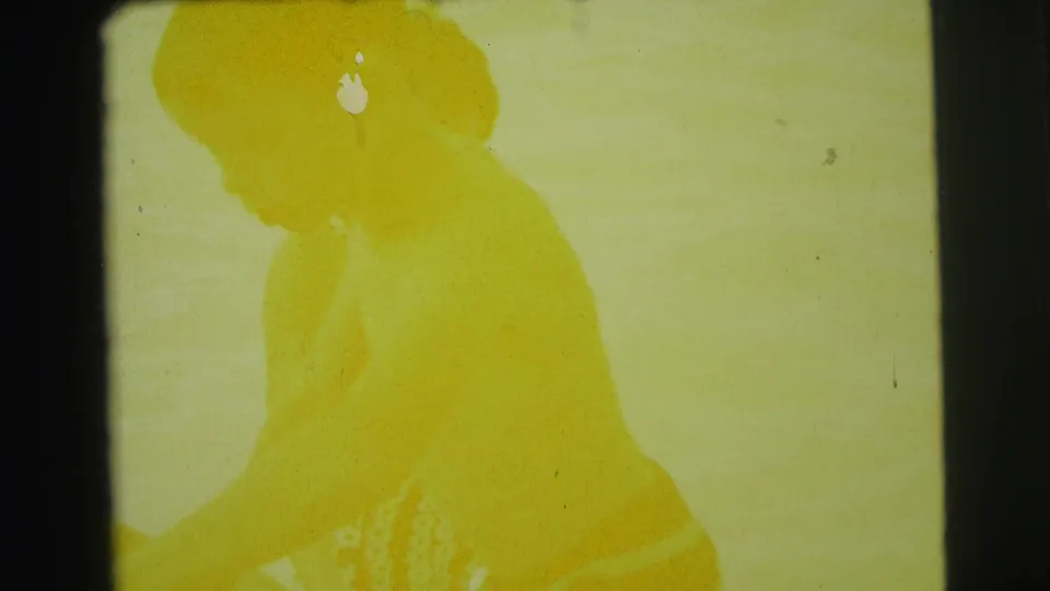 Overexposed 1971 home-movie frame with a yellow-tinted human silhouette, soft background detail, and visible film wear.