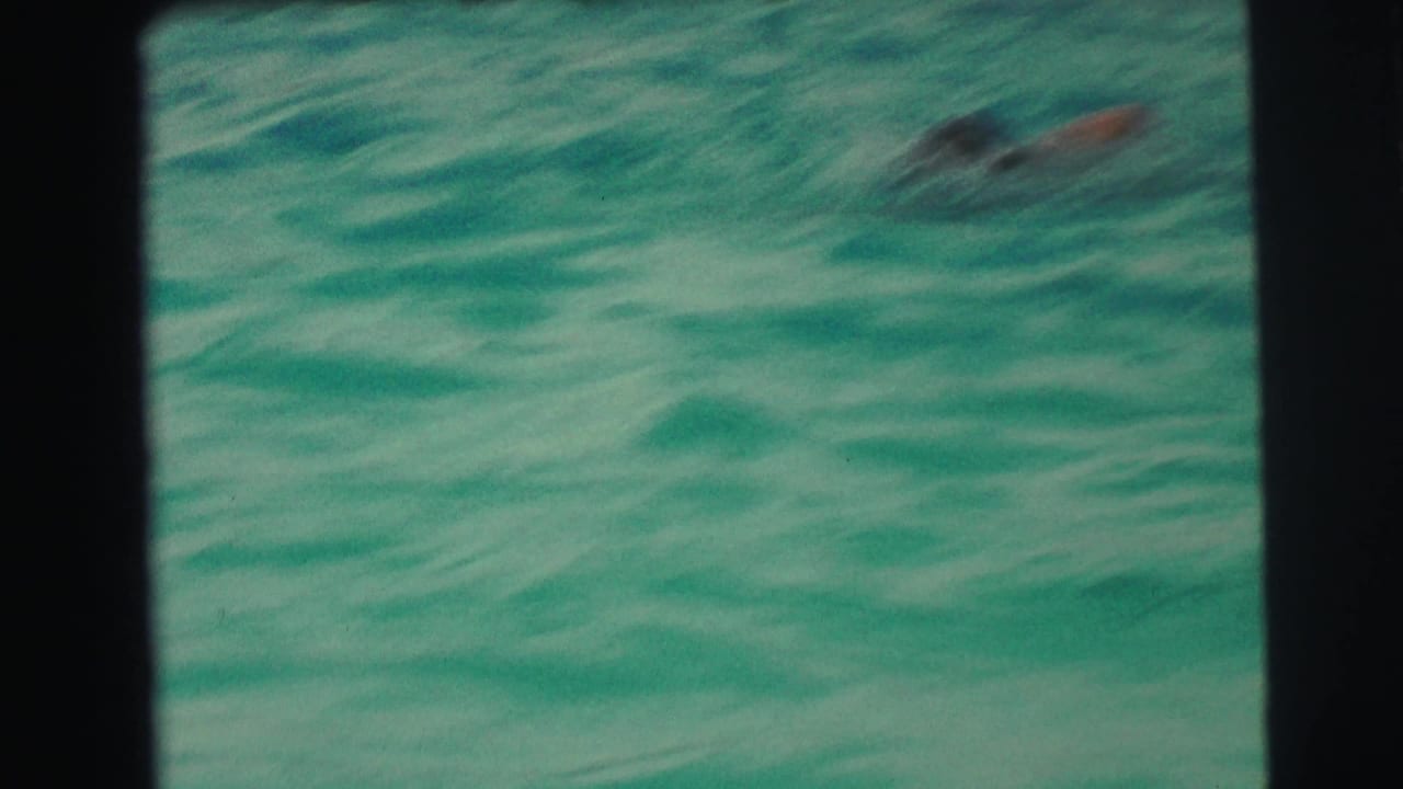 Turquoise pool water with a swimmer blurred near the surface.