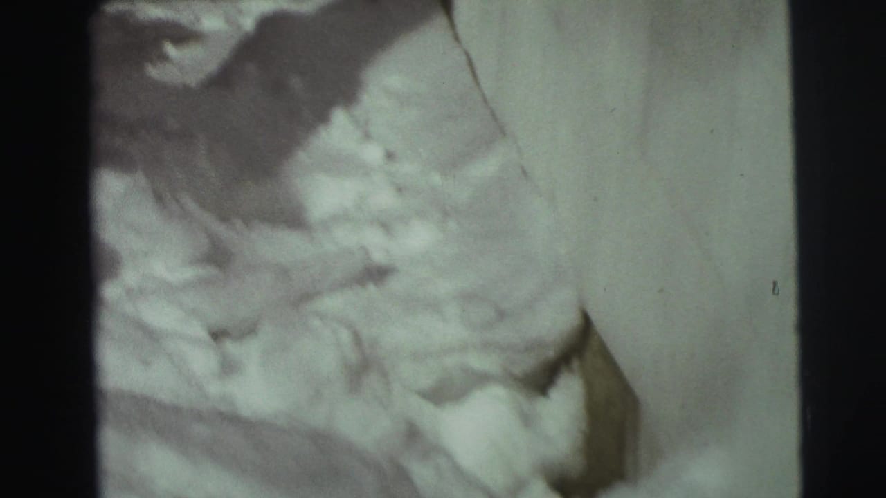 Close view of uneven snow piled against a house exterior.