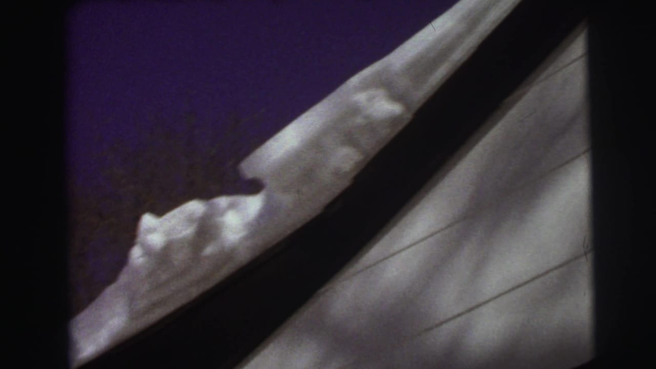 Snow-covered roof edge beside white siding and a dark window frame.