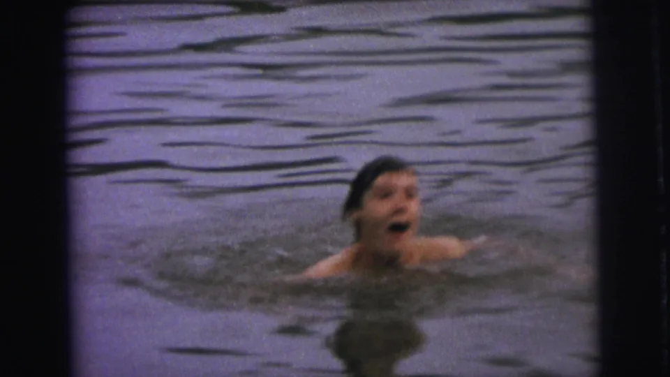 A young swimmer surfaces in lake water in the 1973 Superior, Wisconsin home-movie footage.