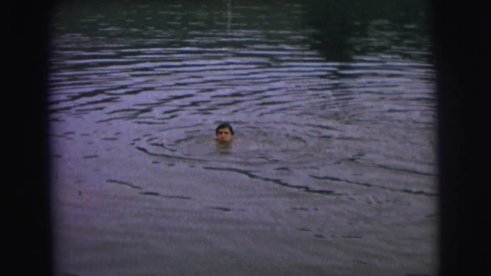 A swimmer's head appears at a distance in rippling lake water in the 1973 Superior, Wisconsin clip.