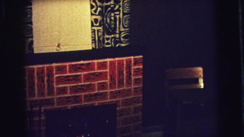 Brick fireplace, patterned curtains, and dark wall surfaces appear inside the Superior, Wisconsin home interior.