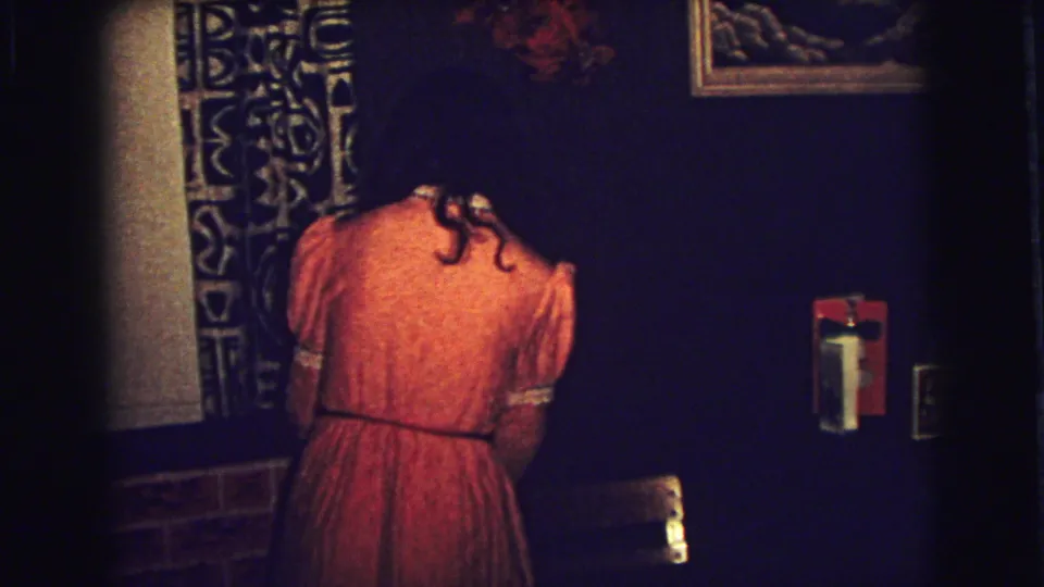 The final frame shows the woman still bent near the patterned curtain and dark wall in the Superior, Wisconsin home interior.
