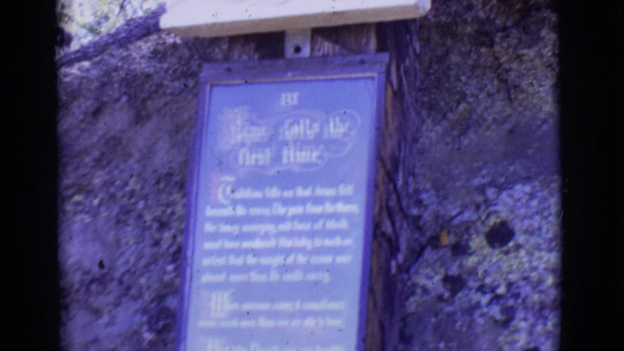 Blue and white plaque on stone wall with a pale wooden feature above it.