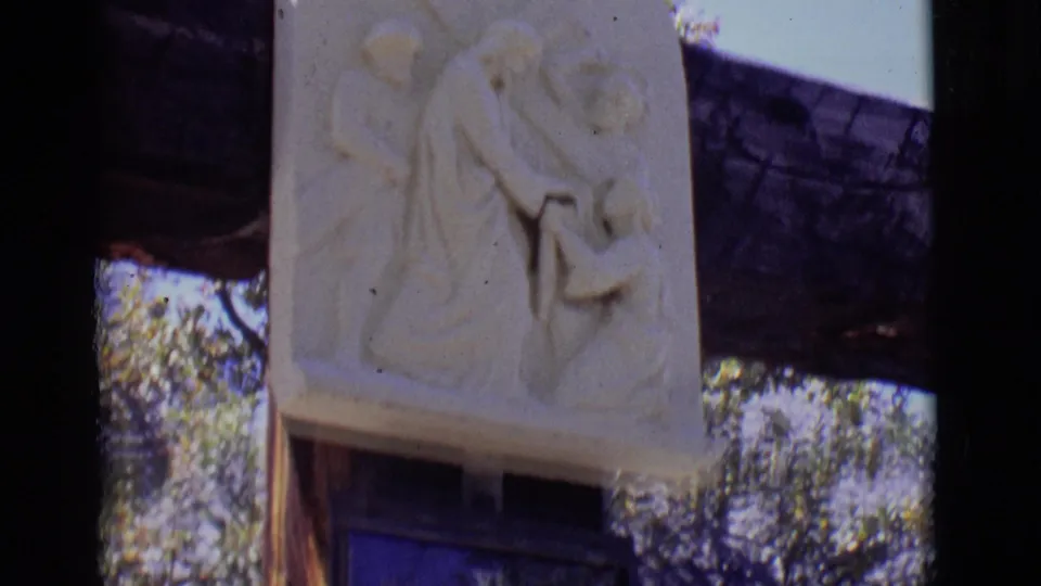 A pale carved relief of Veronica and Jesus appears above the blue Station VI plaque in this 1965 San Luis 8mm frame.