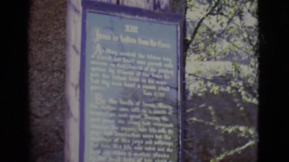 1965 San Luis, Colorado home-movie frame focused on the thirteenth station plaque, Jesus is taken from the cross.