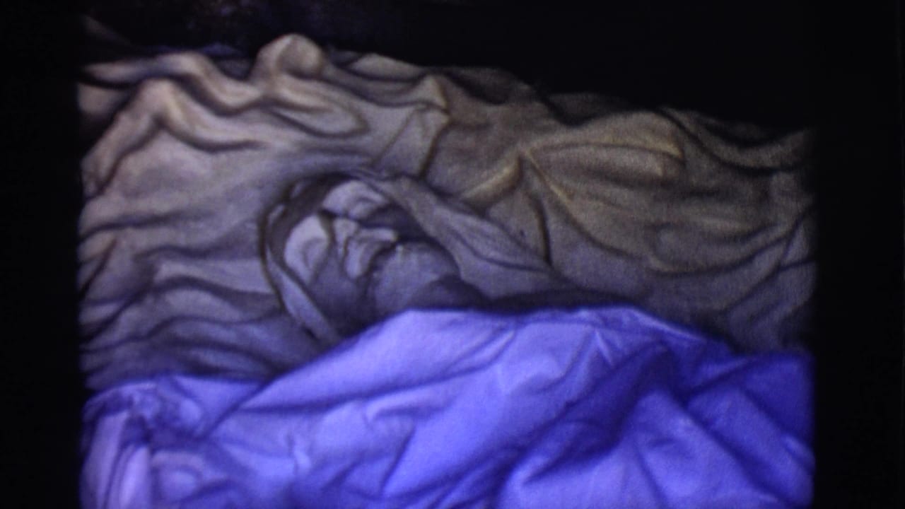 Close view of the covered Jesus statue with blue fabric across the lower body.