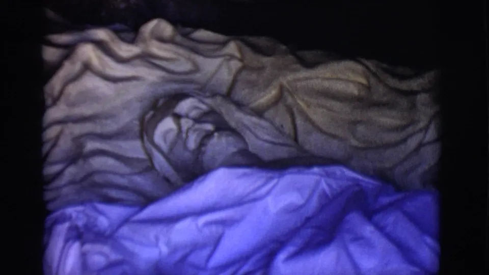 The San Luis, Colorado home-movie frame holds on the statue's face and upper torso, with blue fabric covering the lower portion.