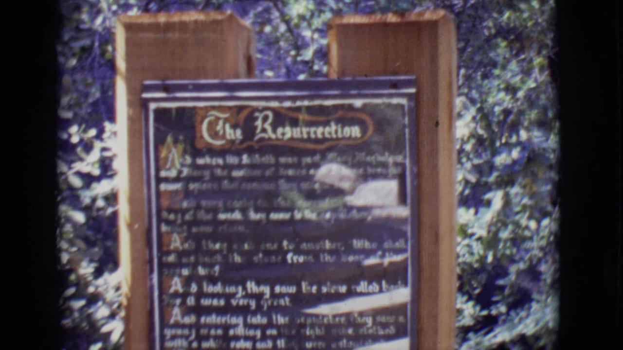 Outdoor Resurrection sign on wood posts with leafy background.