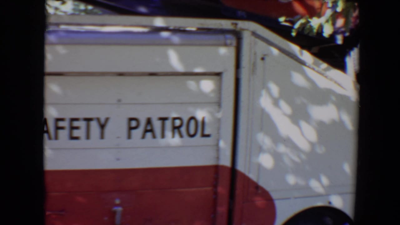 Close 8mm view of the truck side in Evansville, with SAFETY PATROL lettering and red lower body panels.