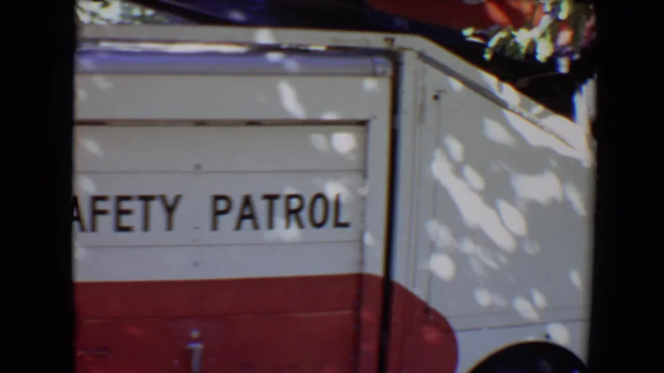 Close 8mm view of the truck side in Evansville, with SAFETY PATROL lettering and red lower body panels.