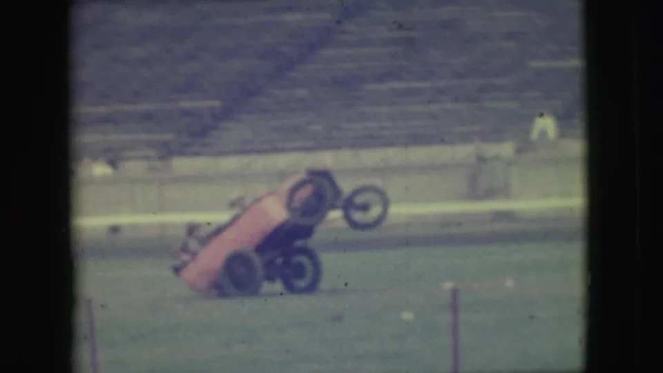 1949 Denver 8mm frame of the red prototype-style car lifting its front end during a wheelie-like stunt.