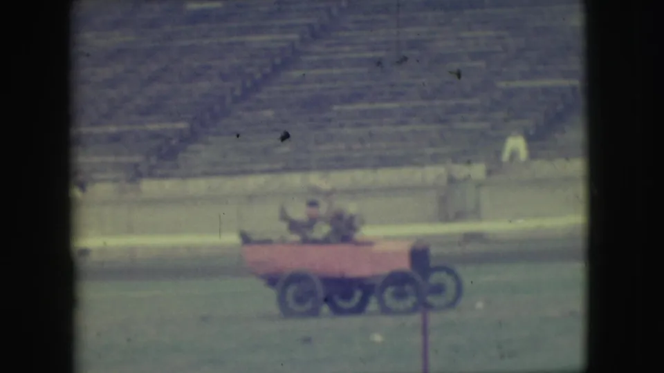 At the end of the 1949 Denver clip, the red experimental vehicle appears level again on the grass before the bleachers.