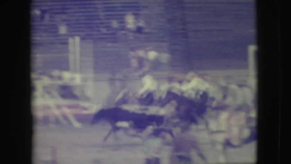 1949 Denver rodeo frame with multiple horses and riders bunched near the rail, seen through heavy motion blur.