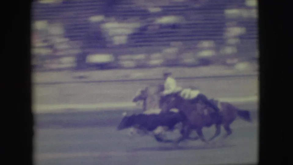 1949 Denver arena footage showing horses running side by side while a rider leans forward above the blurred action.
