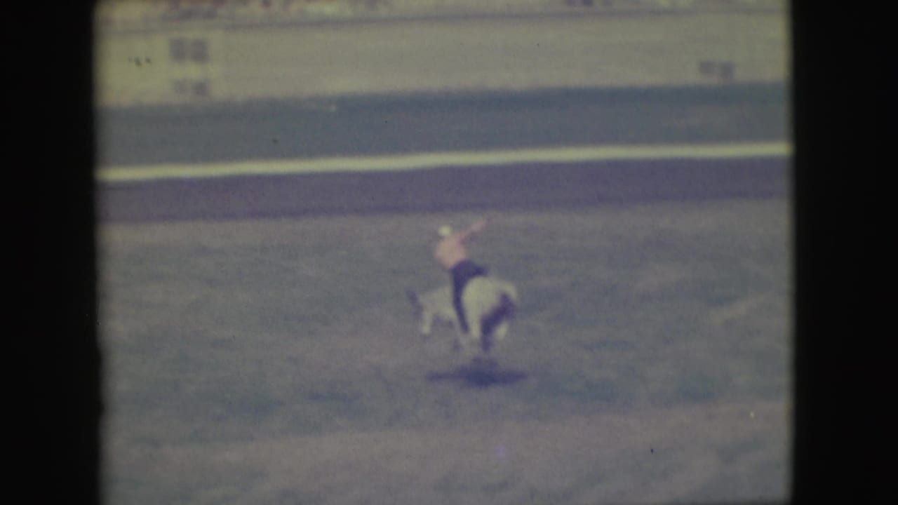 In the Denver 1949 rodeo footage, a cowboy in a light shirt rides a white bull as it bucks across the arena.