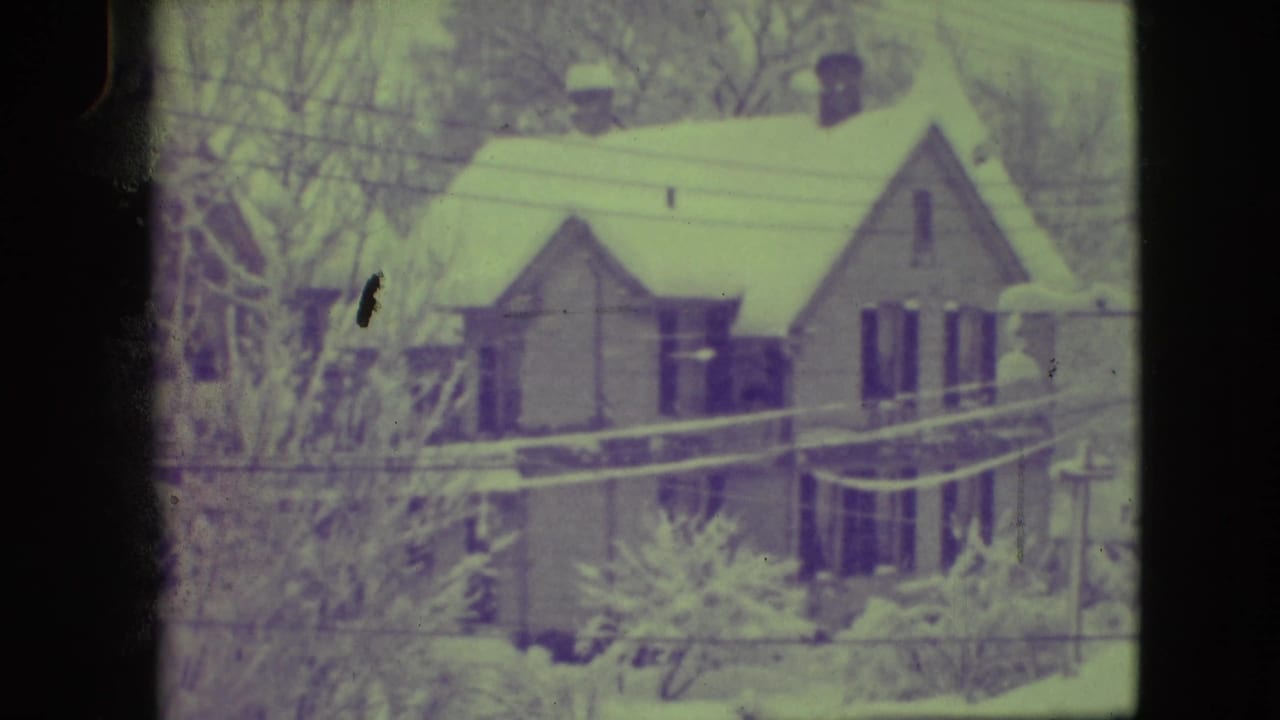 Snow-covered house in Elmwood Park, Illinois, filmed in 1945 with bare trees and utility wires in view.