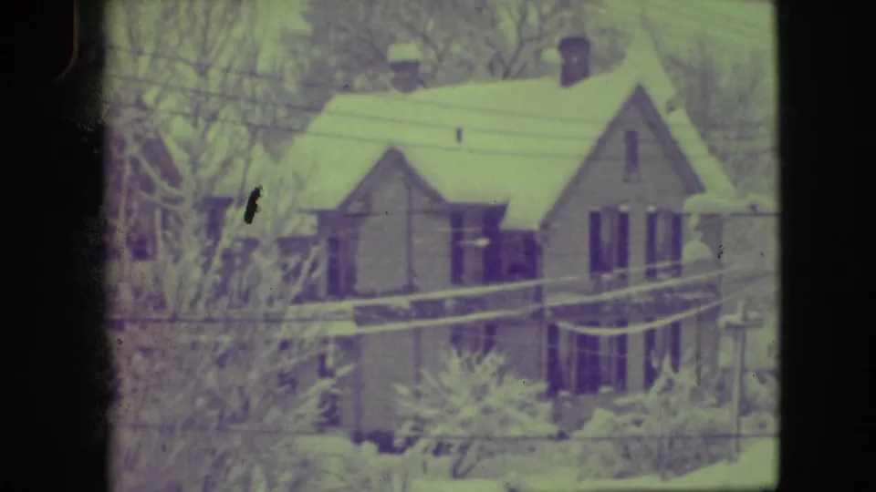 Snow-covered house in Elmwood Park, Illinois, filmed in 1945 with bare trees and utility wires in view.