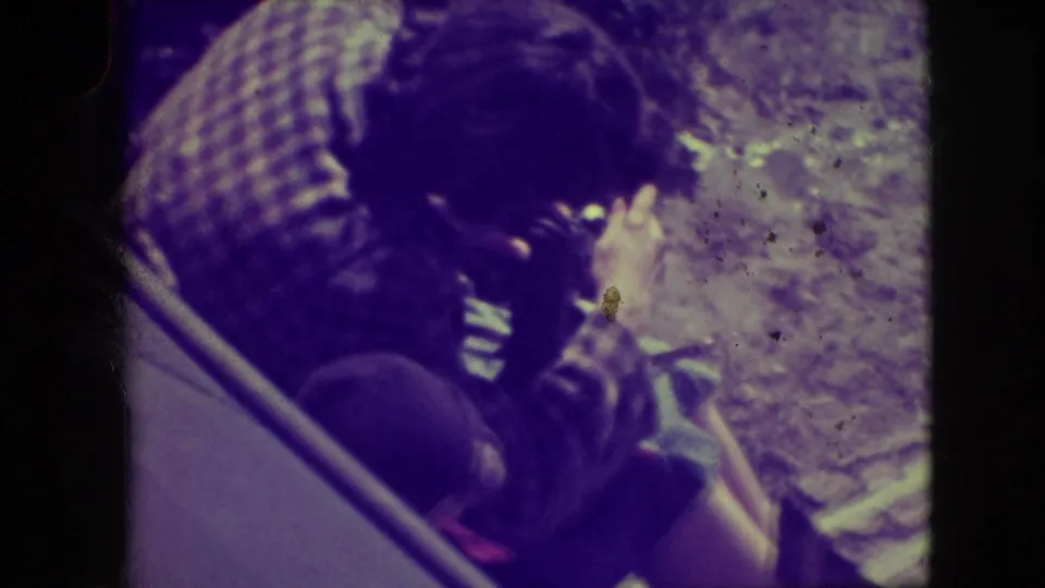 Close home-movie view of a man in plaid handling a small camera in a snowy Elmwood Park outdoor setting.
