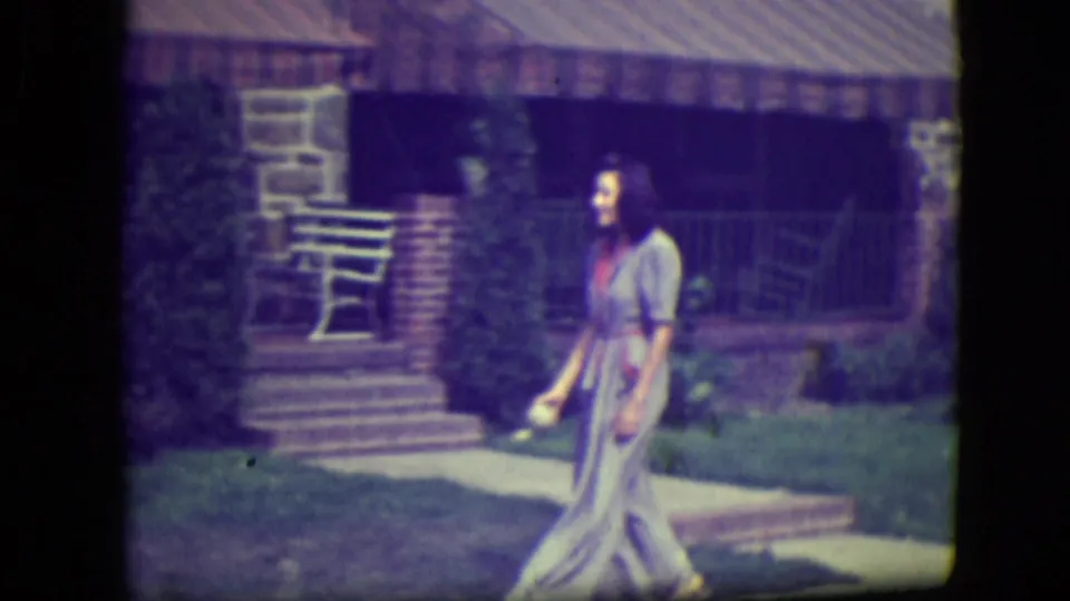 Woman stands by a front walkway holding what appears to be a ball near a brick porch in 1946 River Forest footage.