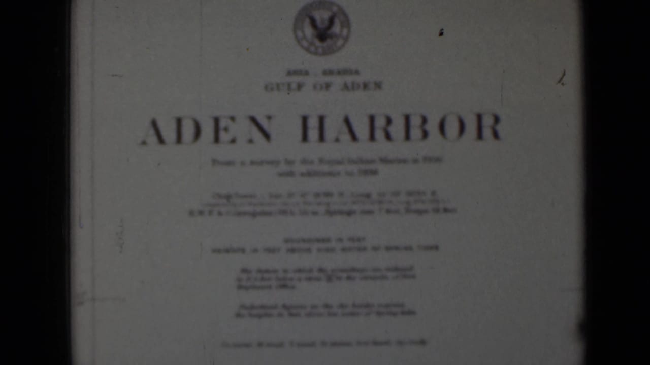 Aden Harbor title card framed slightly to the right with dark film edges.