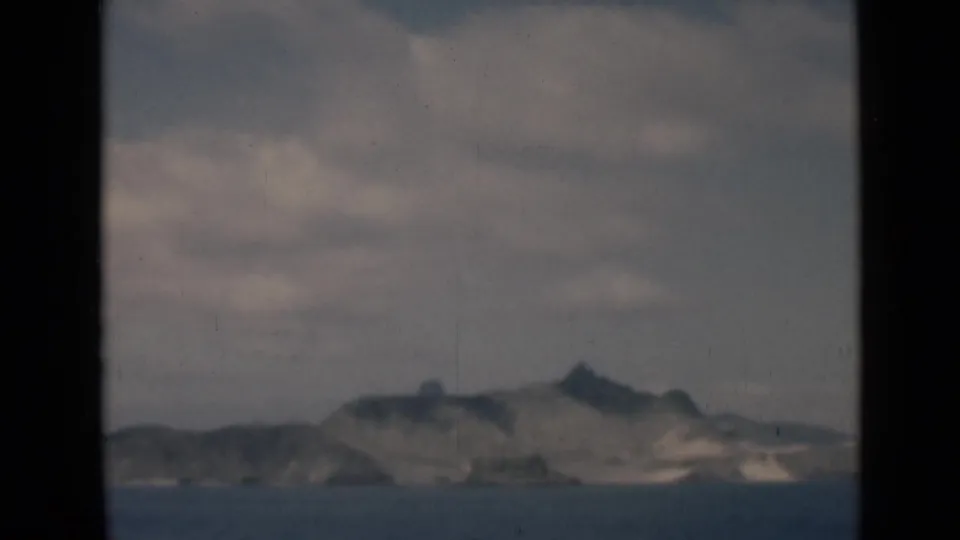 1946 8mm frame associated with Aden, Yemen, showing a hazy mountainous coast and sea through dark window framing.