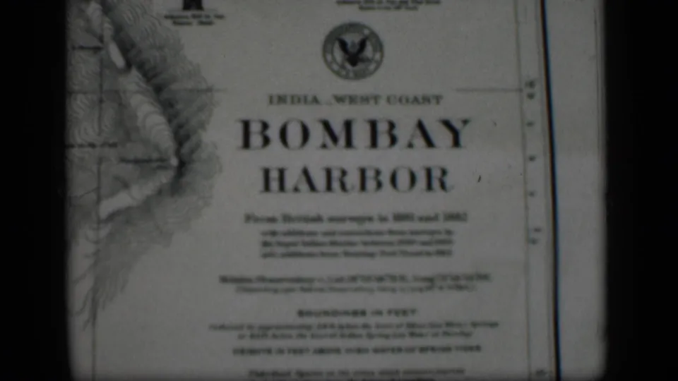 1946 8mm frame showing a printed Bombay Harbor nautical chart with survey text and visible film gate edges.