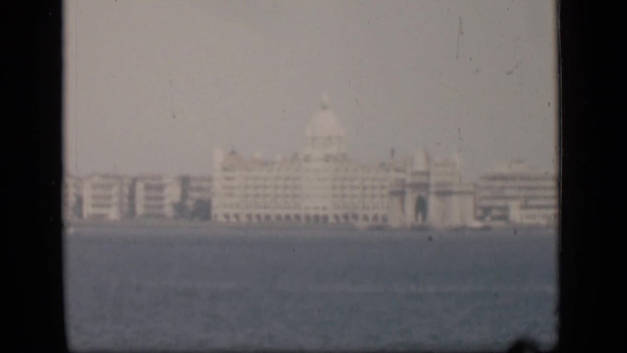 1946 Bombay waterfront view with a distant pale domed building softened by haze across the water.