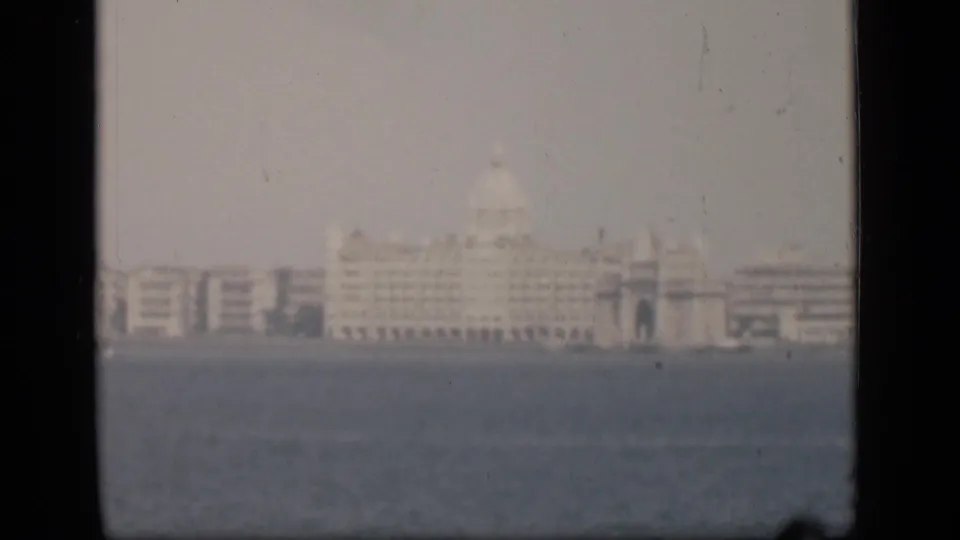 1946 Bombay waterfront view with a distant pale domed building softened by haze across the water.