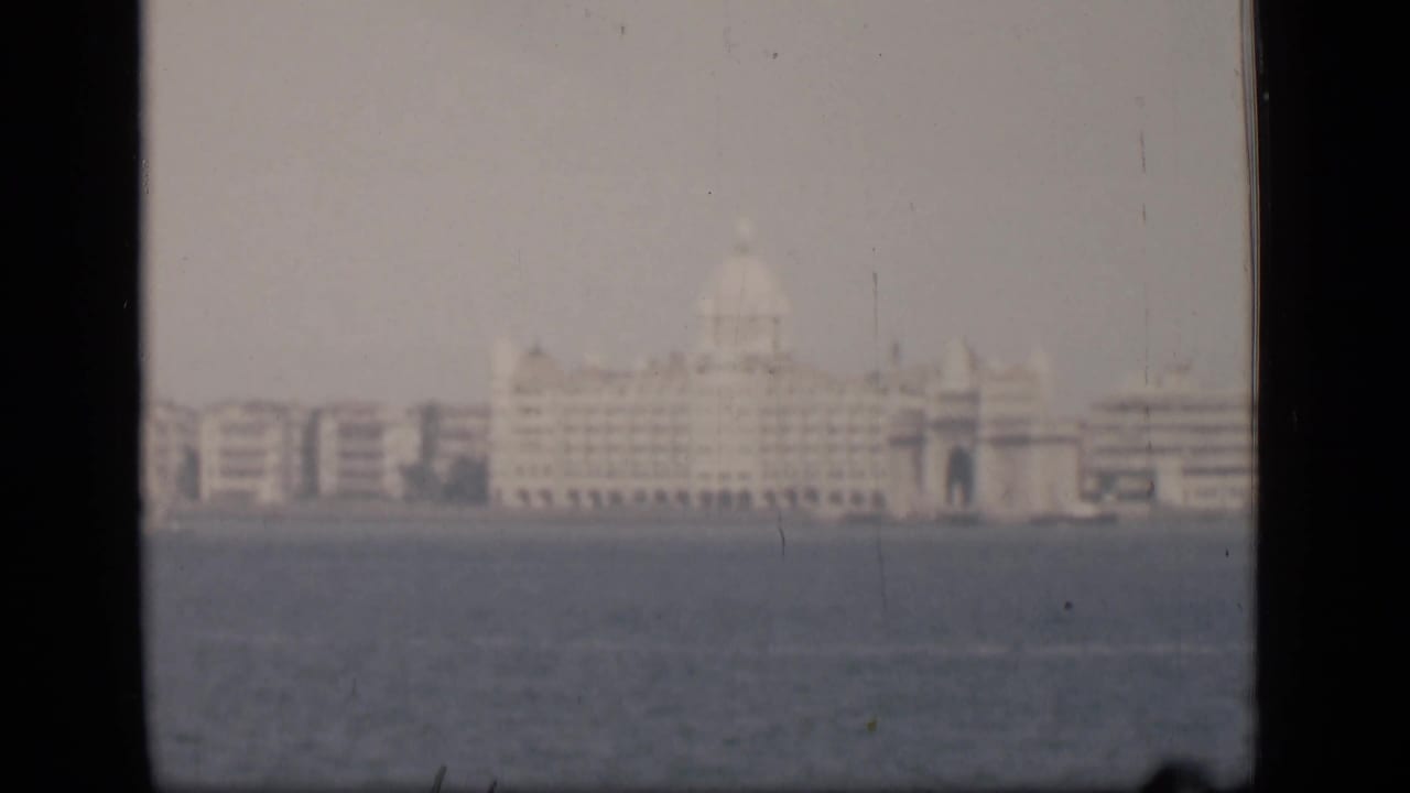 A soft 1946 Bombay view across the harbor, with the Taj Mahal Palace Hotel area appearing in haze.