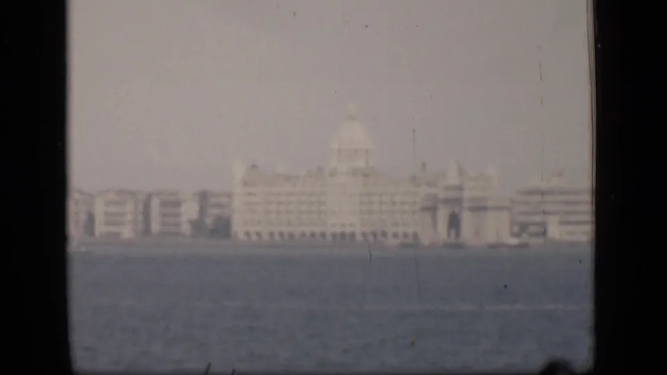 A soft 1946 Bombay view across the harbor, with the Taj Mahal Palace Hotel area appearing in haze.