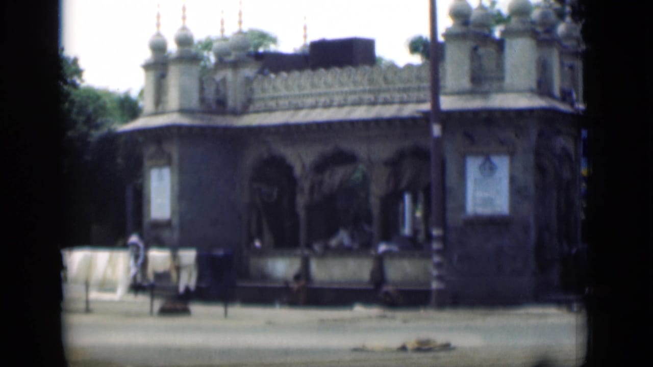 Ornate domed building beside open pavement with hanging laundry nearby.