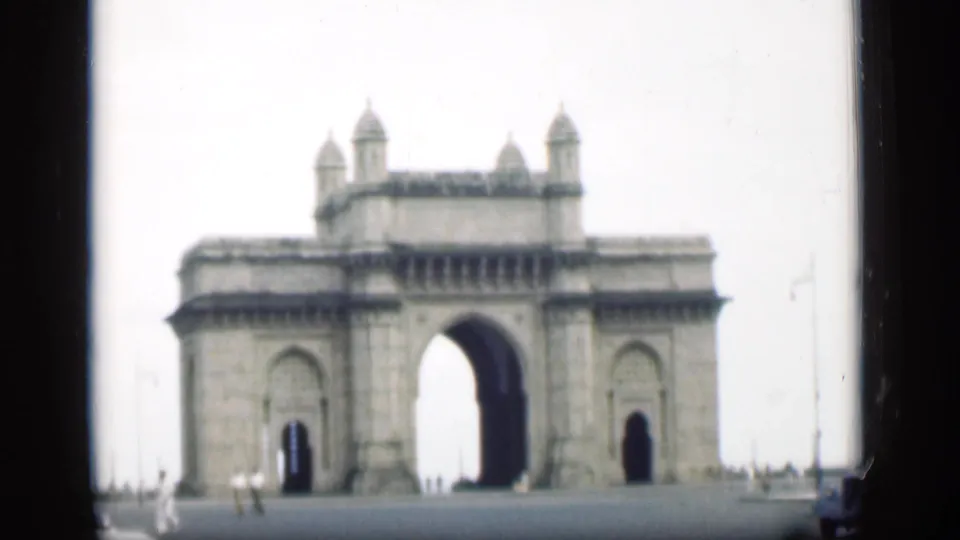 1946 Bombay view of the Gateway of India, with its large central arch, smaller side arches, and distant pedestrians.