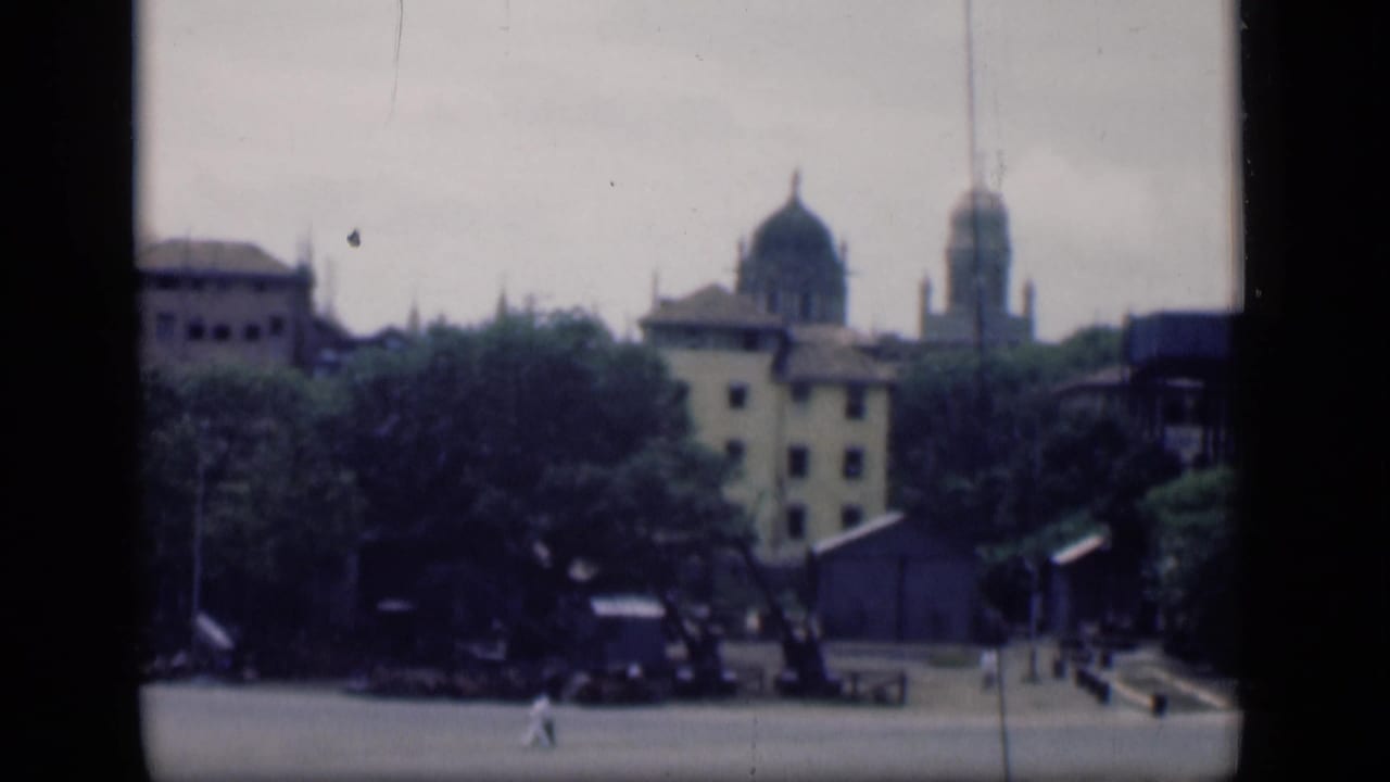 Similar city view with domed buildings, trees, plaza, and a few pedestrians.