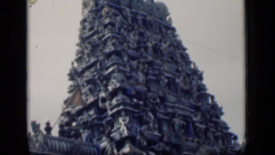 1946 Bombay home-movie frame showing the upper portion of an ornate South Indian temple gopuram against a pale sky.