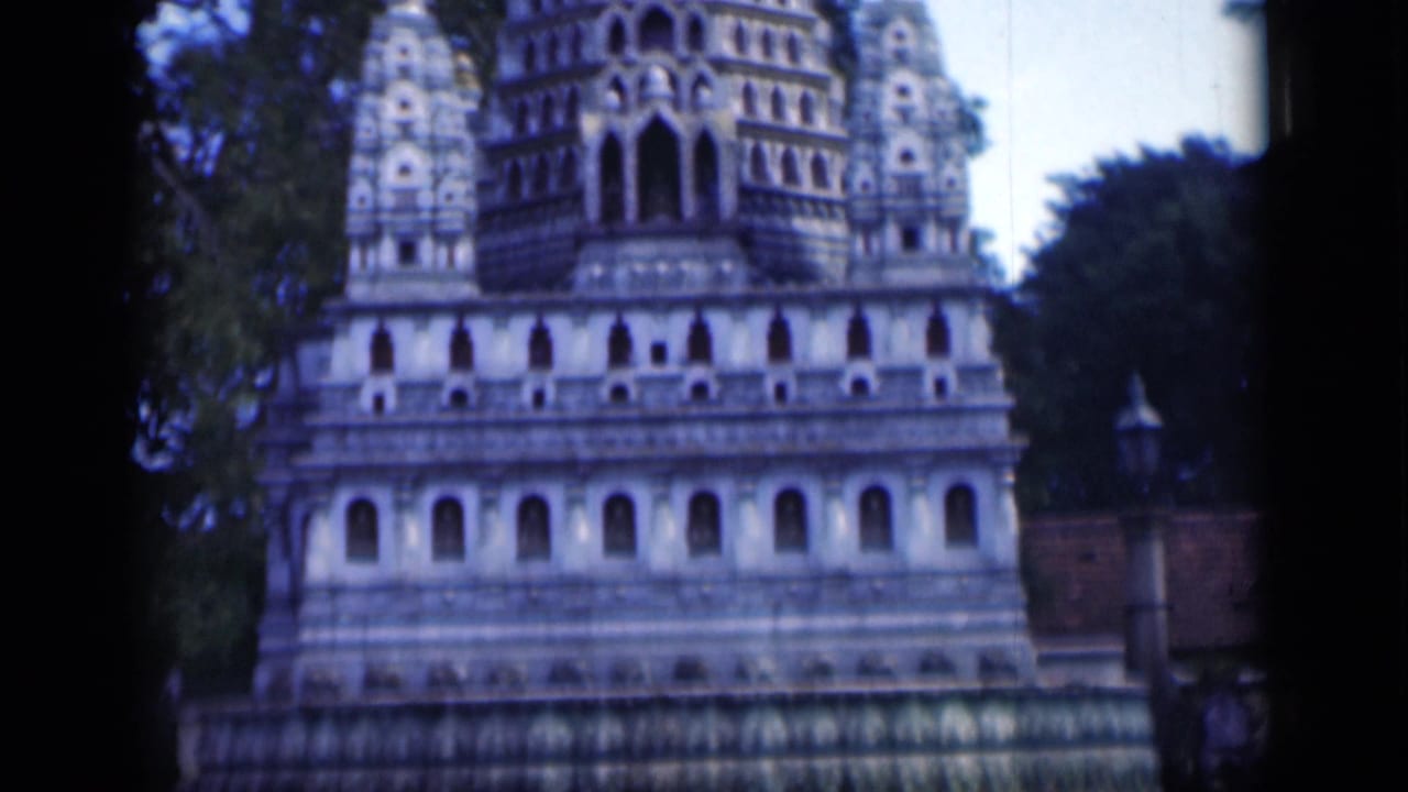 Ornate tiered temple structure partly framed by trees.