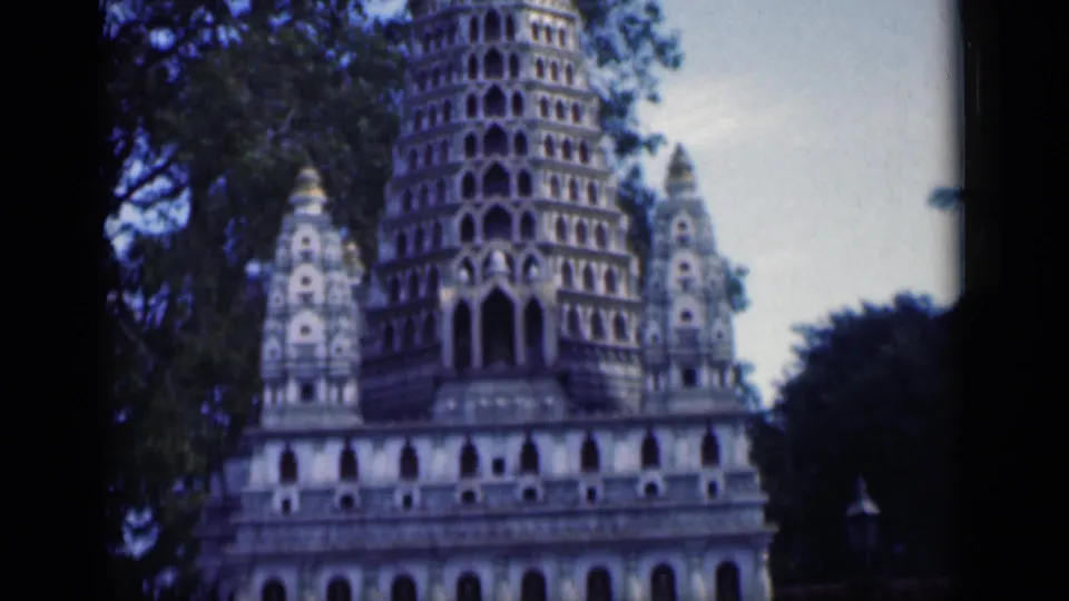 Soft 8mm frame from 1946 Bombay showing carved temple towers, arched openings and leafy trees.