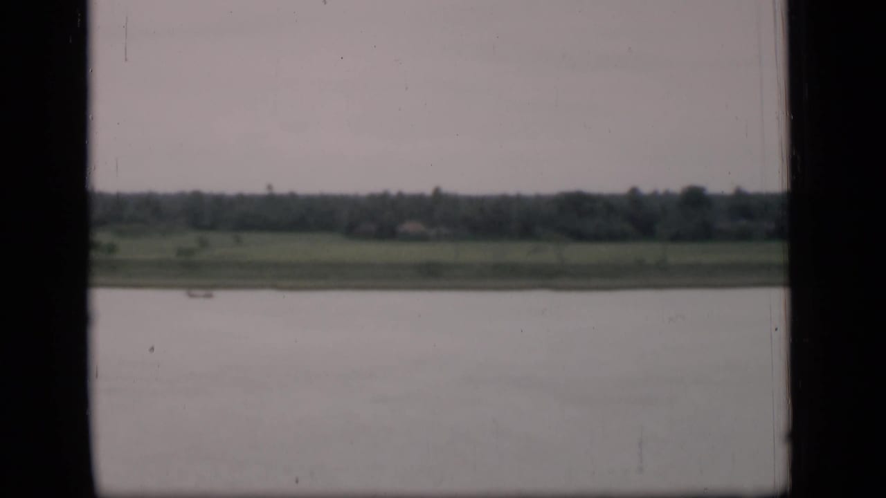 Wide river view with distant trees and a small boat near the far shore.
