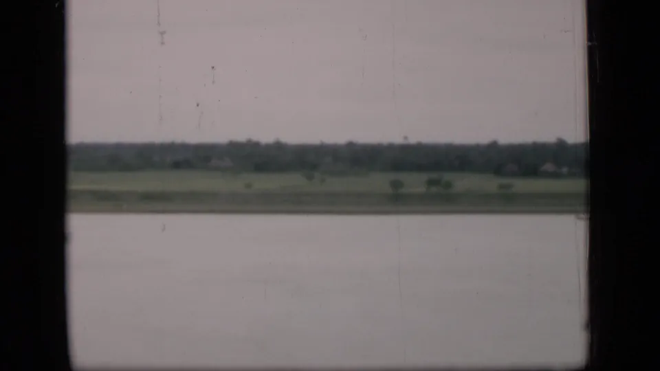 A final 1946 Bombay-area frame shows water, low fields, and a distant treeline beneath a gray sky, partially obscured by dark window borders.