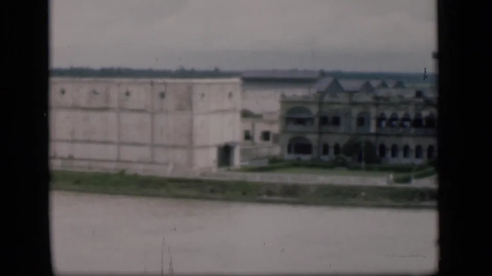 End of the Bombay waterfront pan, showing a pale wall, part of the arched riverfront structure, a smokestack, and the river foreground.