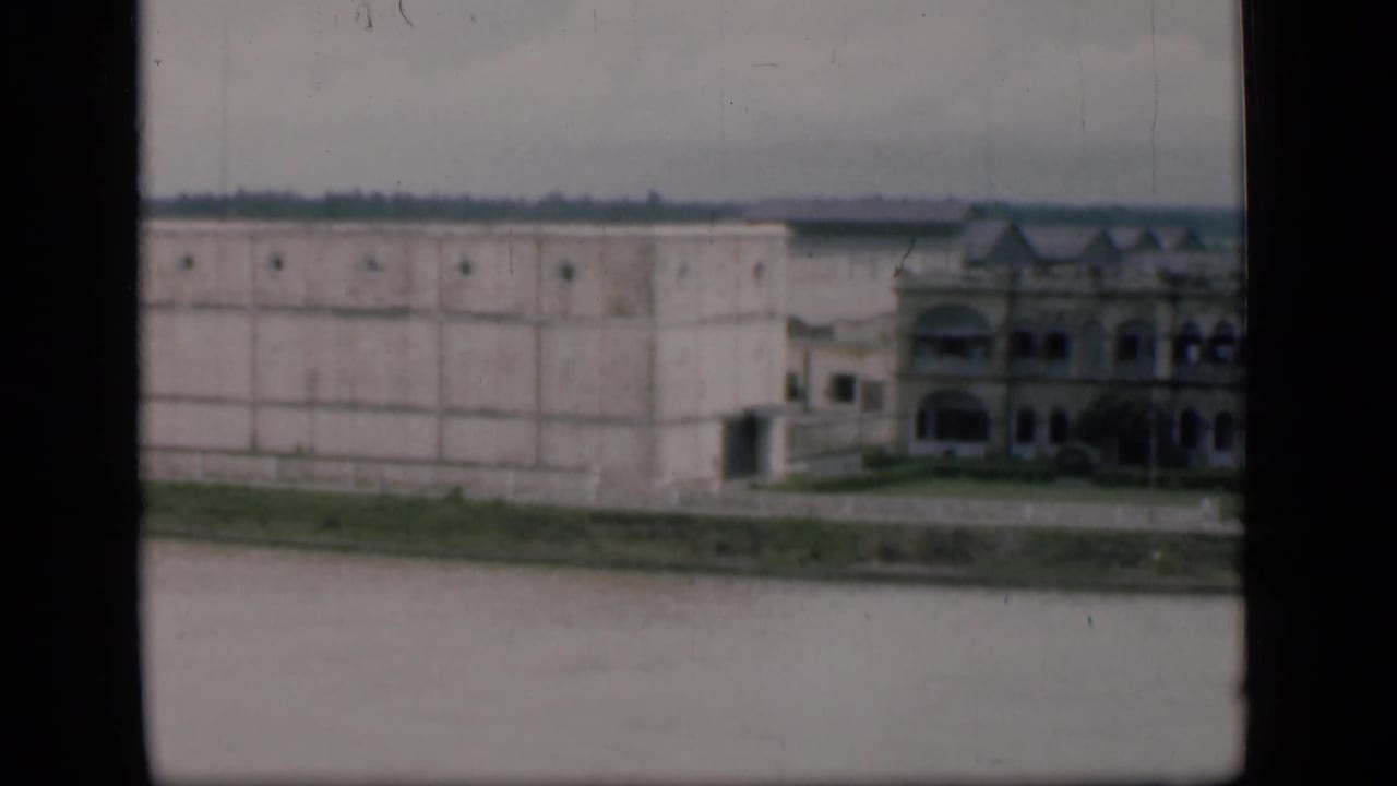 1946 Bombay waterfront view of a large pale rectangular building with grid-like walls and an ornate end section, seen from across water.