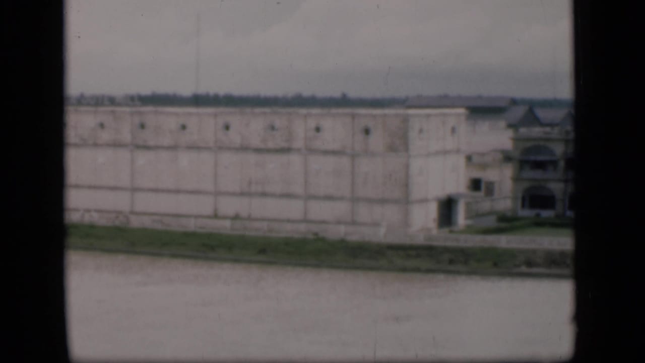 A 1946 Bombay pan frame shows the long white building facade beside water, with a partial ornate structure at the far right.