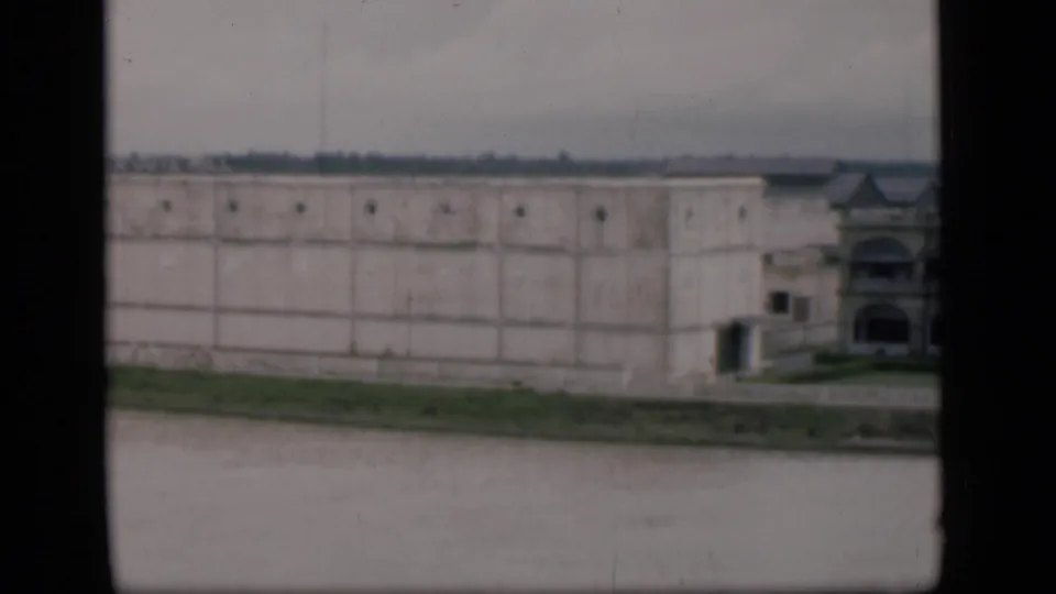 A 1946 Bombay pan frame shows the long white building facade beside water, with a partial ornate structure at the far right.