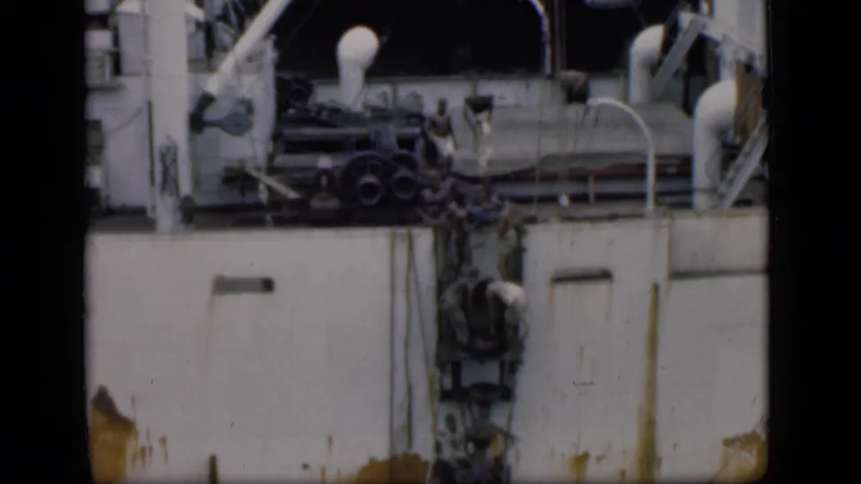 Bombay, India, 1946 footage showing workers on the side of a large ship, with rusted white hull panels and deck equipment in view.