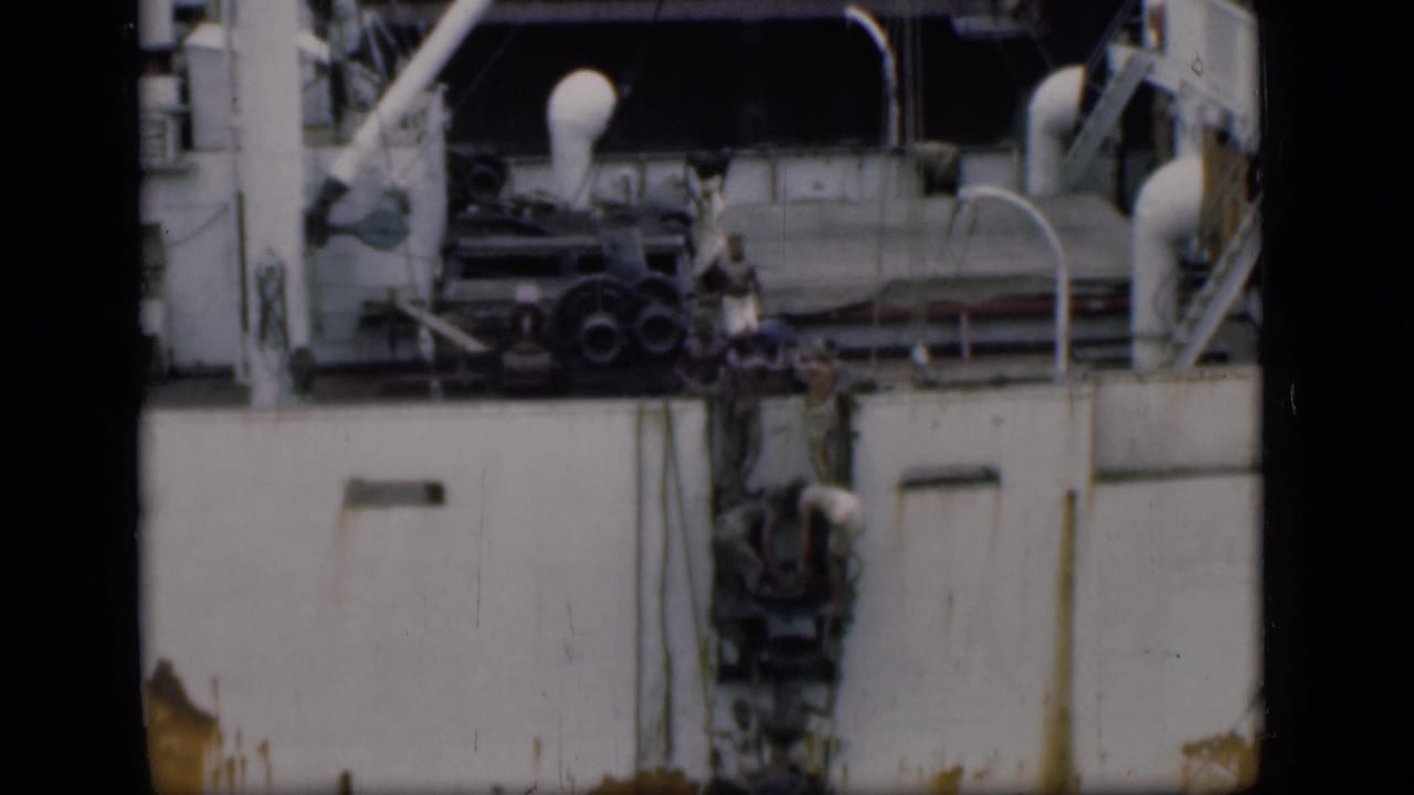 1946 Bombay footage showing people climbing or standing by a ladder against a large white ship with visible railings and equipment.