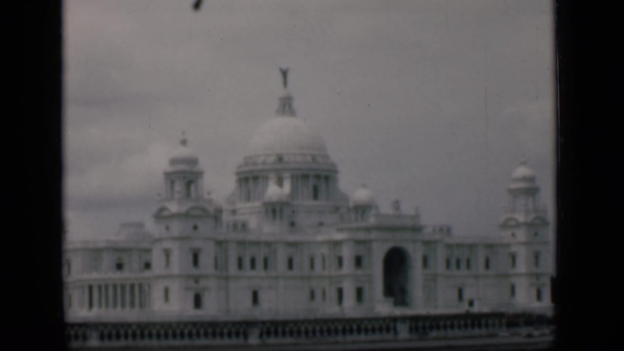 White domed palatial building with turrets under a grey sky.