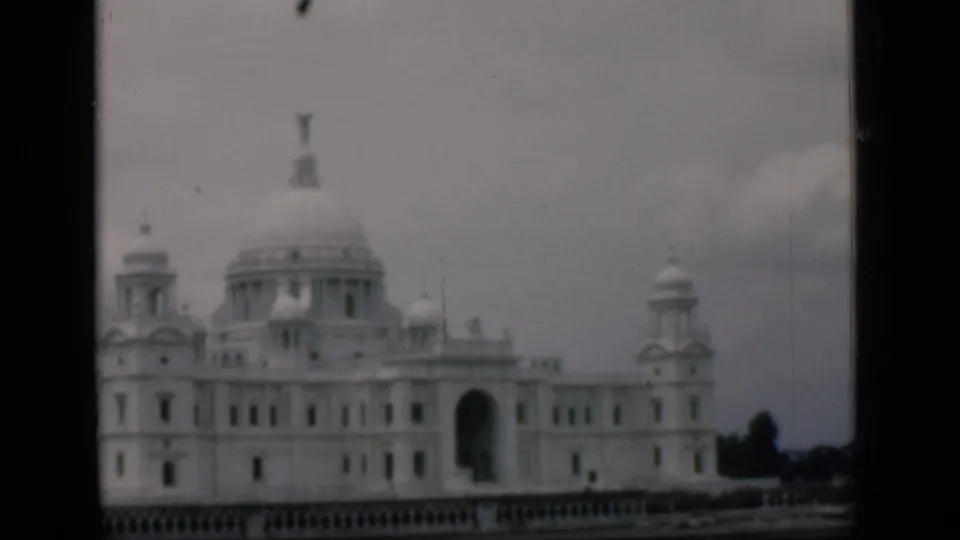 A handheld 8mm frame from Bombay in 1946 shows the white domed landmark slightly lower in view beneath an overcast sky.