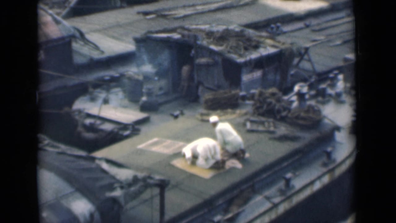 The Calcutta boat deck scene shows one man kneeling in prayer on a mat as another man in white stands nearby among ropes and cargo.